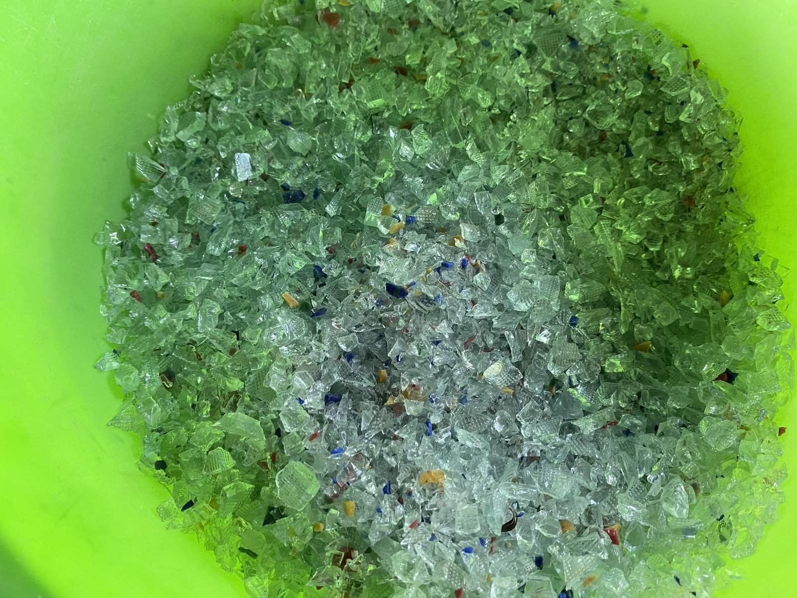 Clear and greenish crushed glass grit close-up